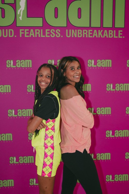 A SLAAM player back-to-back with a family member.
