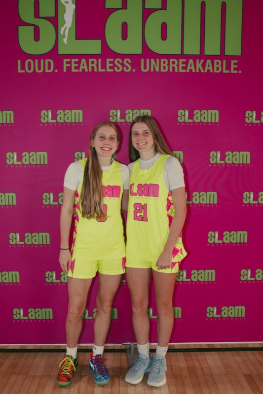 Two SLAAM players in front of the program logo.