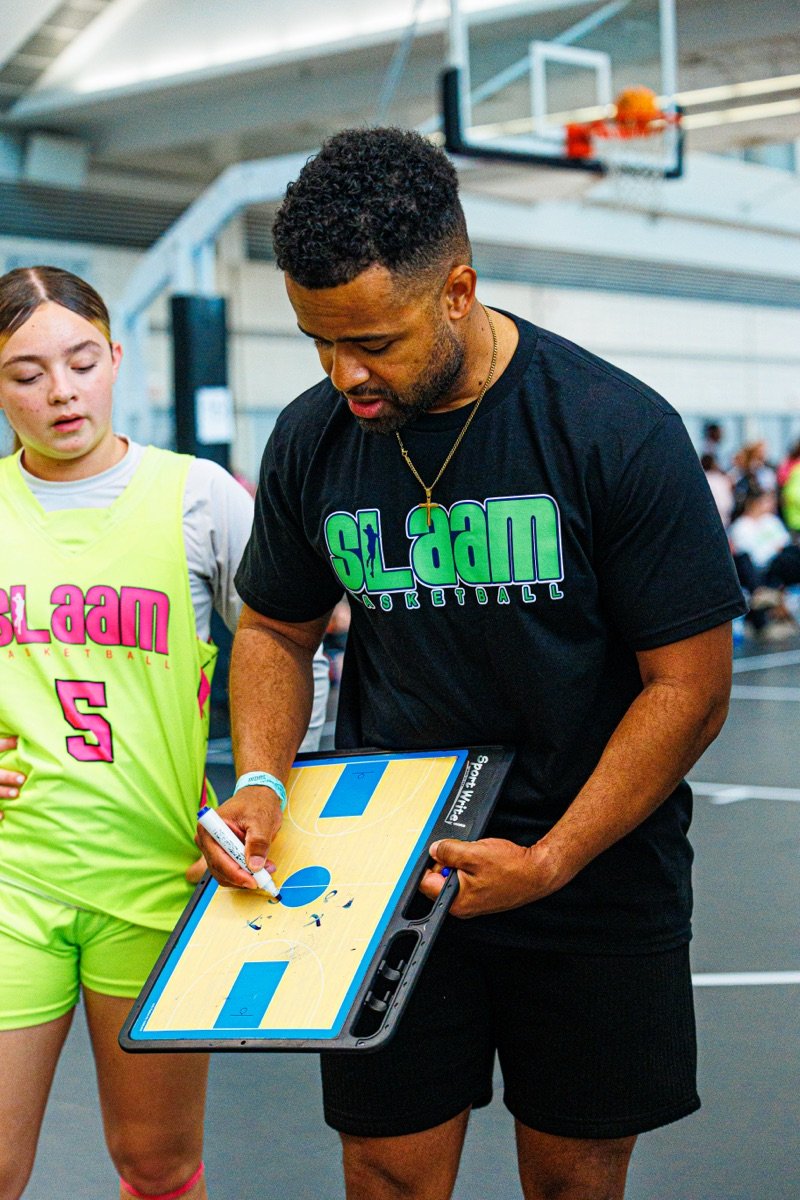 A SLAAM coach drawing up a play with a player.